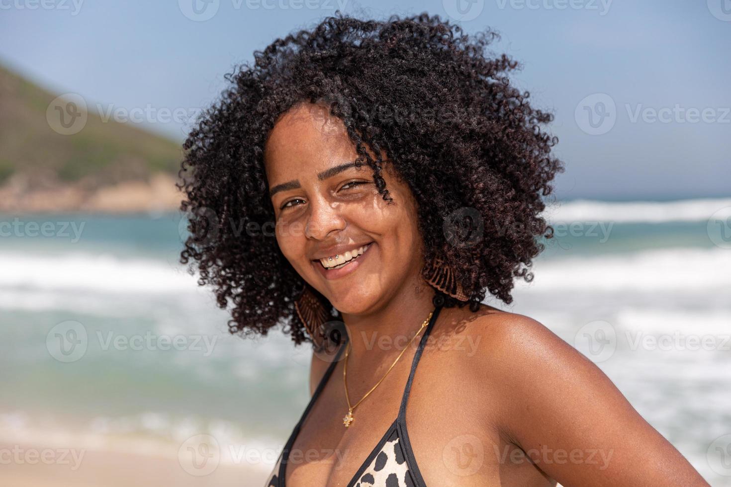 schwarzes afro junges süßes mädchen, lockiges haar, bikini, strand. afroamerikanischer Sommerurlaub. foto