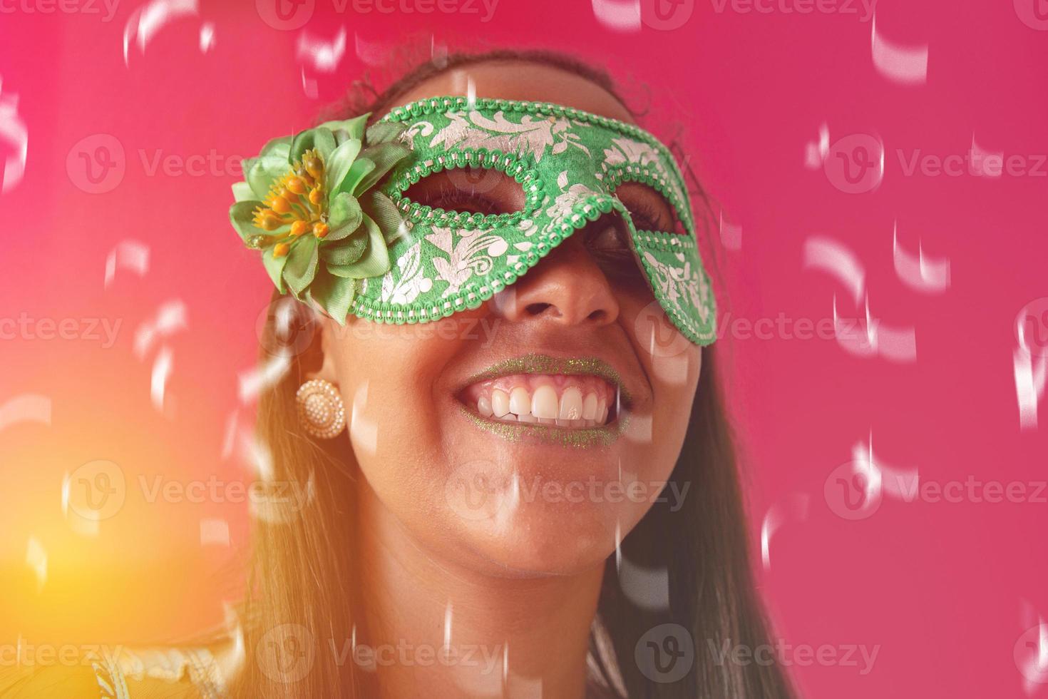 glückliche junge frau mit maske und konfetti auf karnevalsparty. brasilianischer Karneval foto