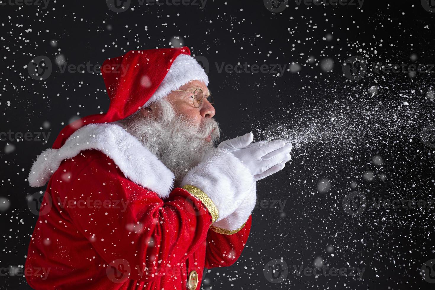 weihnachtliche Traditionen. der weihnachtsmann bläst schneeflocken. foto
