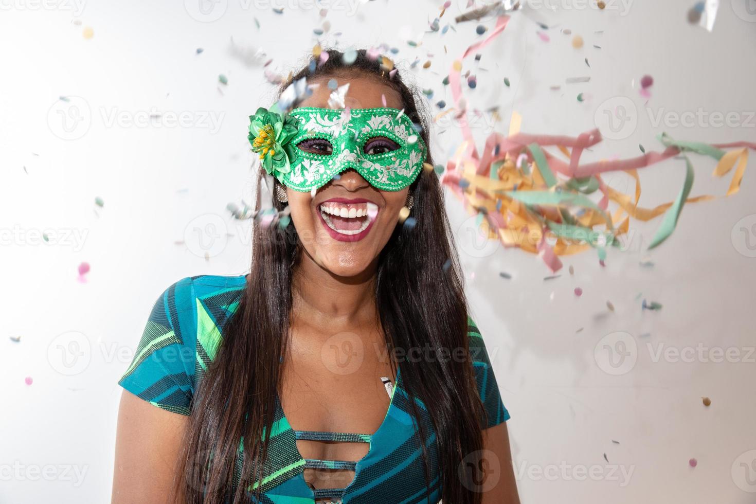 glückliche junge frau mit maske und konfetti auf karnevalsparty. brasilianischer Karneval foto