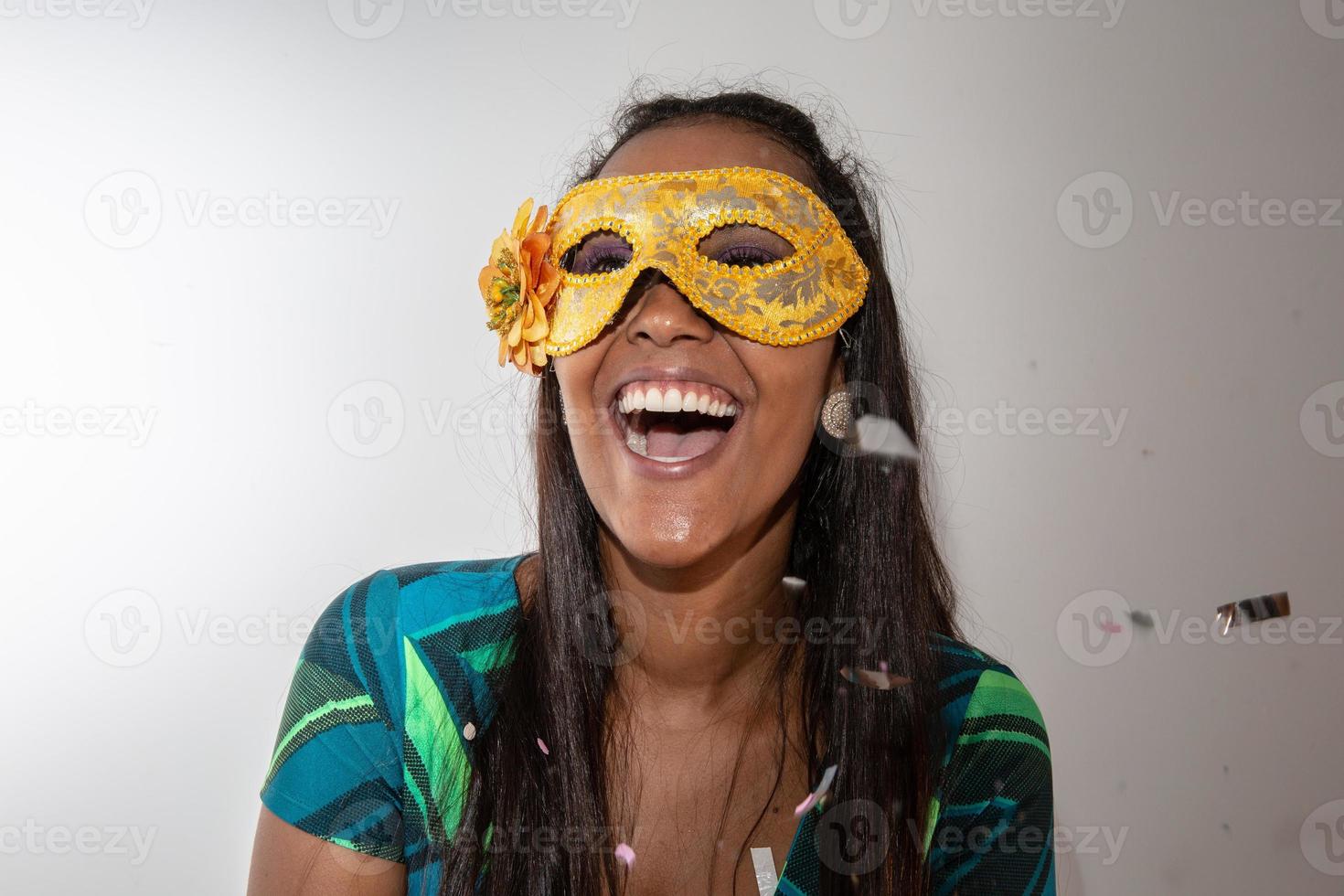 glückliche junge frau mit maske und konfetti auf karnevalsparty. brasilianischer Karneval foto