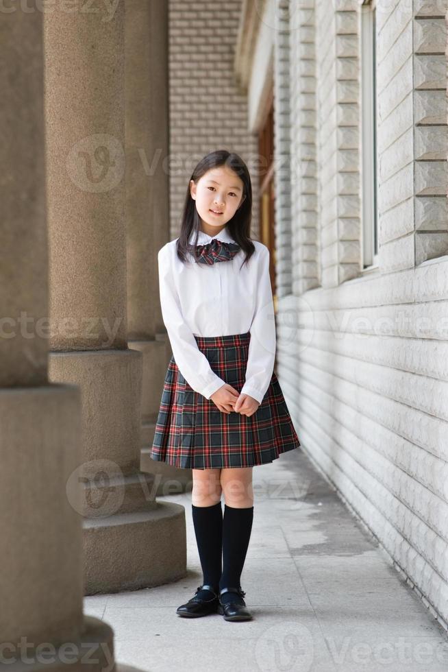 junges Schulmädchen posiert in Schuluniform foto