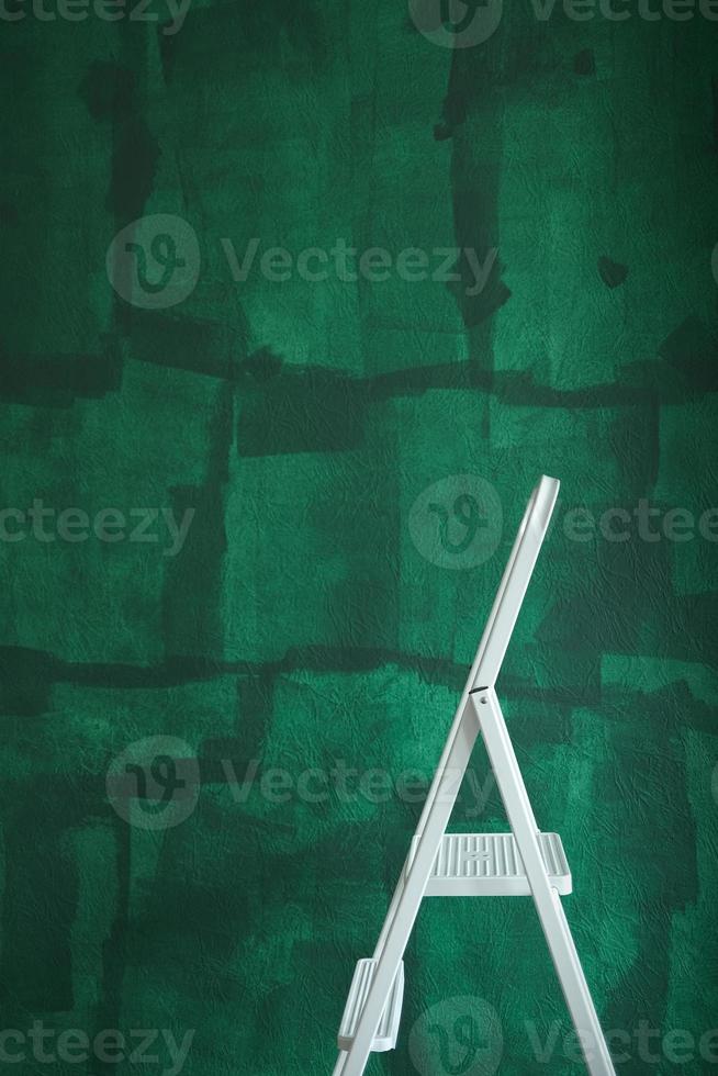 Weiße Trittleiter und grüne unfertige Wand, Heimwerkerkonzept. Innenerneuerung Porträtfoto. foto