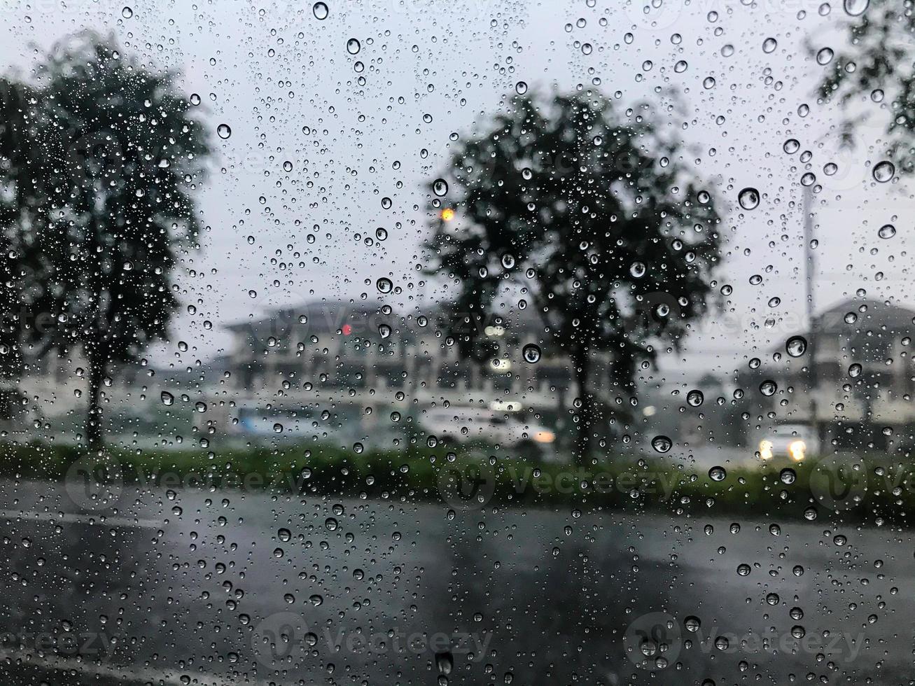 starker regen und regentropfen auf dem autofenster muss das auto unterwegs anhalten. für die sicherheit beim fahren weil ich den weg nicht sehen kann, kann es während der fahrt zu einem unfall kommen. foto
