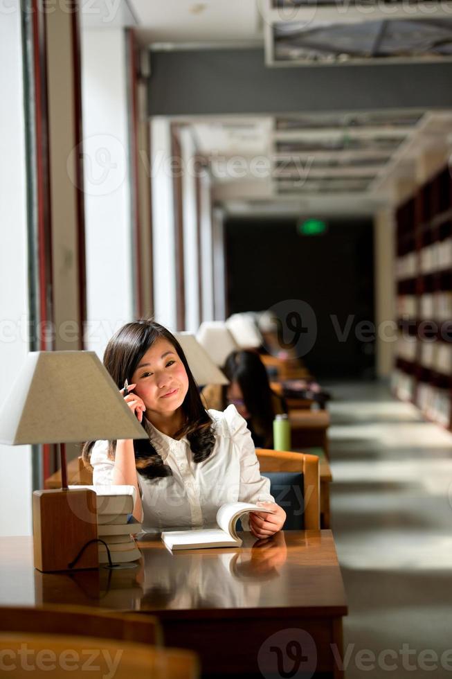 Frau liest Buch in der Bibliothek foto