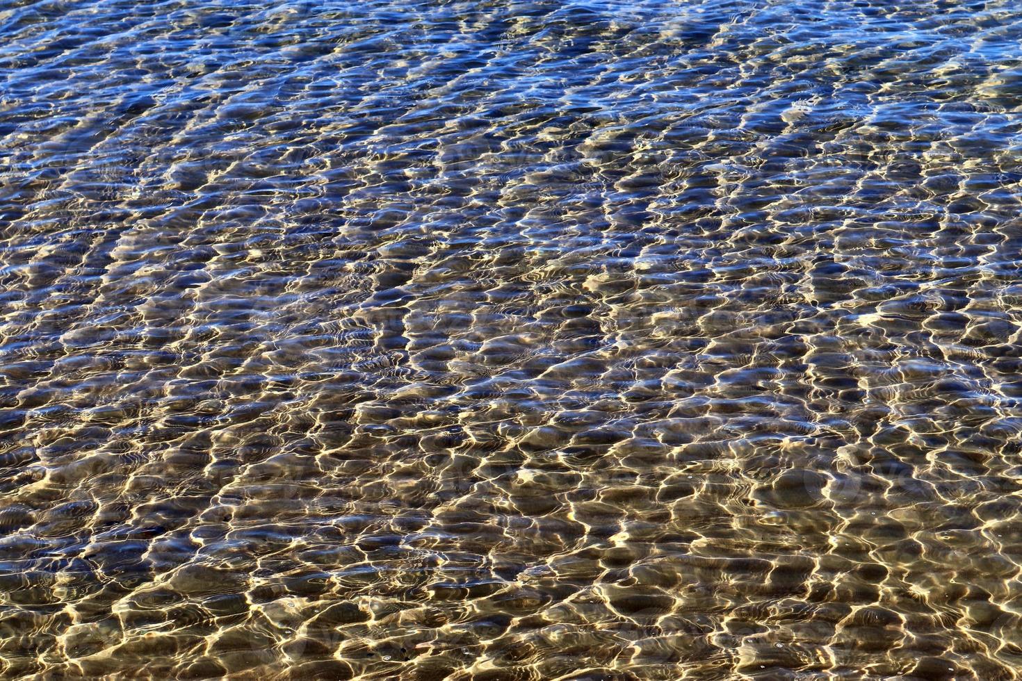 detaillierte nahaufnahme auf wasseroberflächen mit wellen und wellen und das sonnenlicht, das an der oberfläche reflektiert wird foto