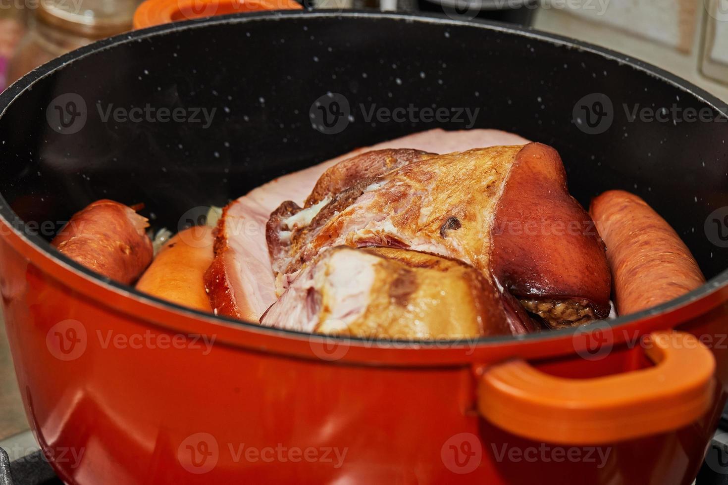 stücke von geräuchertem schweinefleisch und würstchen im topf zur herstellung von elsässischem sauerkraut foto