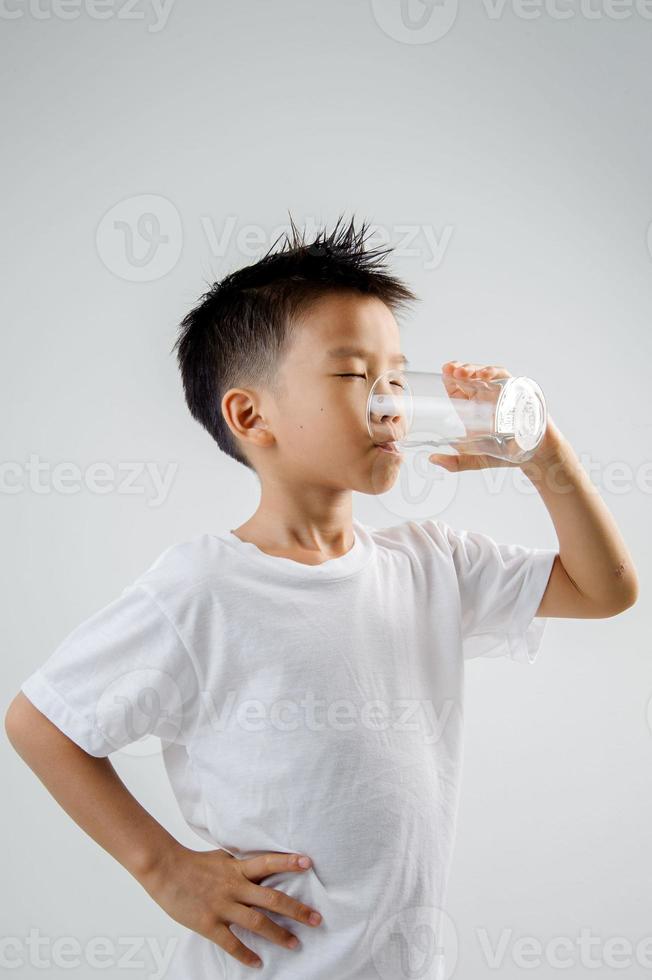 Junge trinke Wasser aus Glas foto