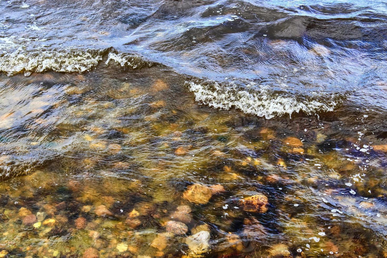 detaillierte nahaufnahme auf wasseroberflächen mit wellen und wellen und das sonnenlicht, das an der oberfläche reflektiert wird foto