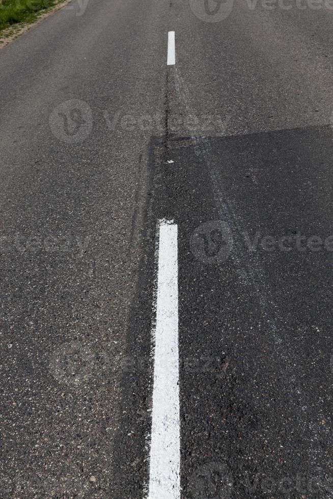 asphaltierte straße mit weißen straßenmarkierungen für das transportmanagement foto