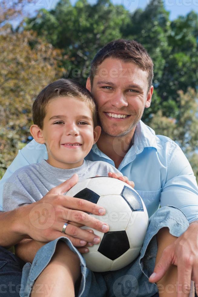 fröhlicher Vater und Sohn mit Fußball foto