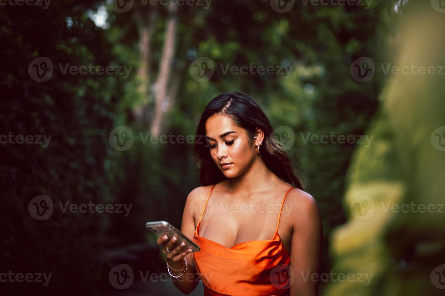 Porträt einer schönen jungen Mischlingsfrau mit Handy. foto