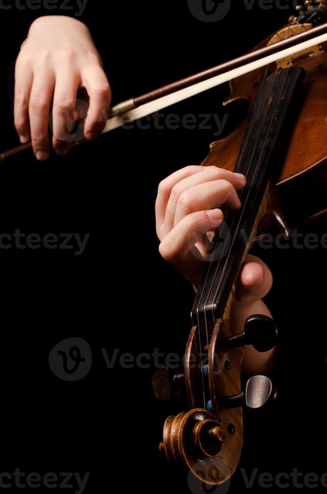 weibliche Hände spielen eine Geige auf dem Schwarz foto