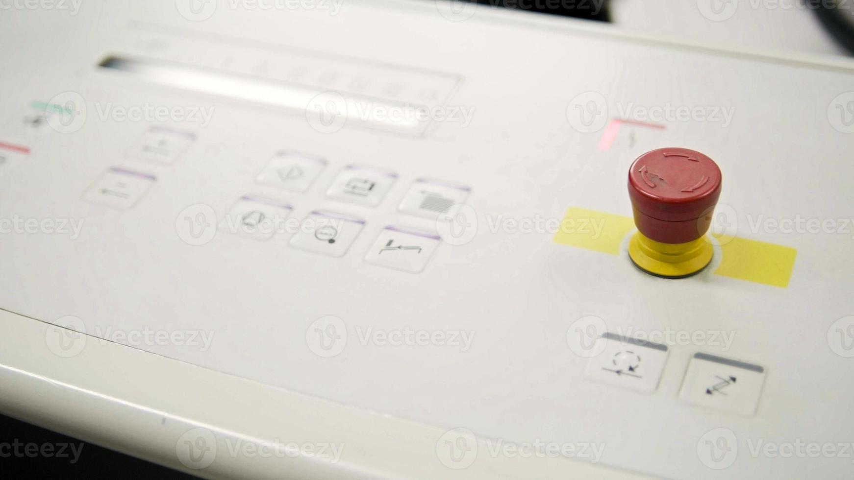 Falzmaschine in der Druckpolygraphenindustrie - roter Knopf und Förderband, Nahaufnahme foto