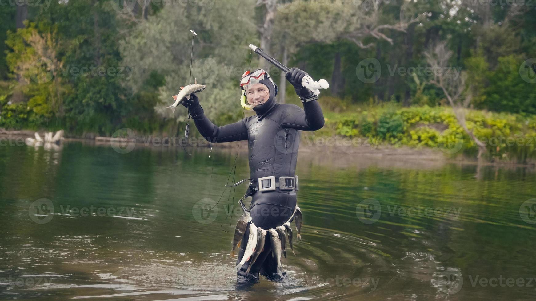 Speerfischer zeigt Süßwasserfische unter Wasser nach der Jagd im Waldfluss foto