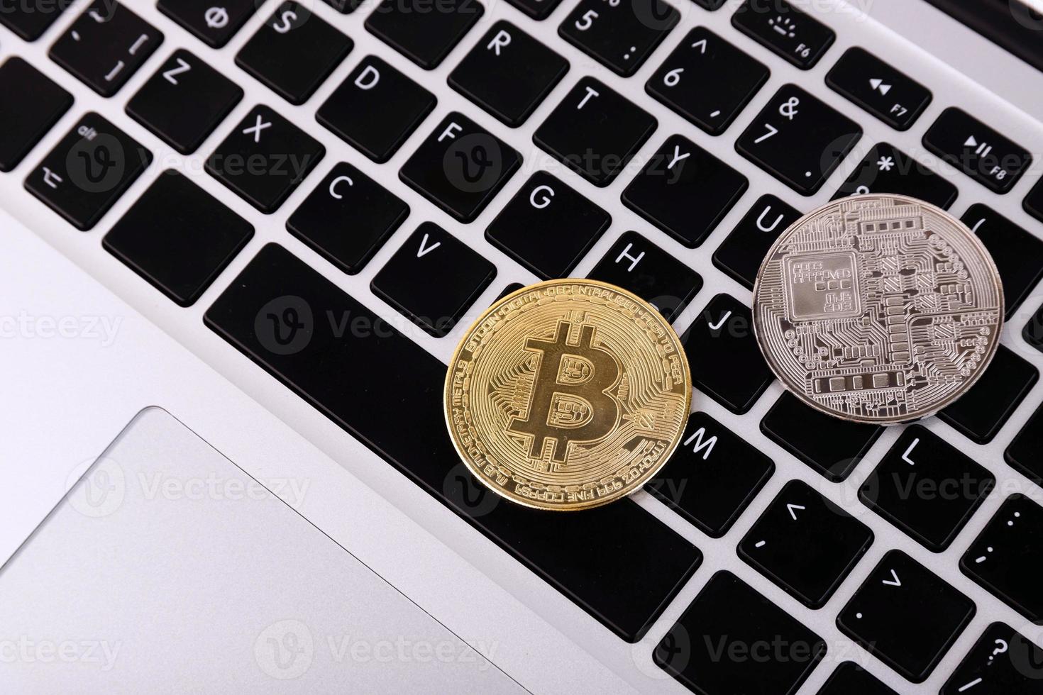 Kryptowährung und Platin- und Gold-Bitcoin auf der Laptop-Tastatur. Konzept. foto