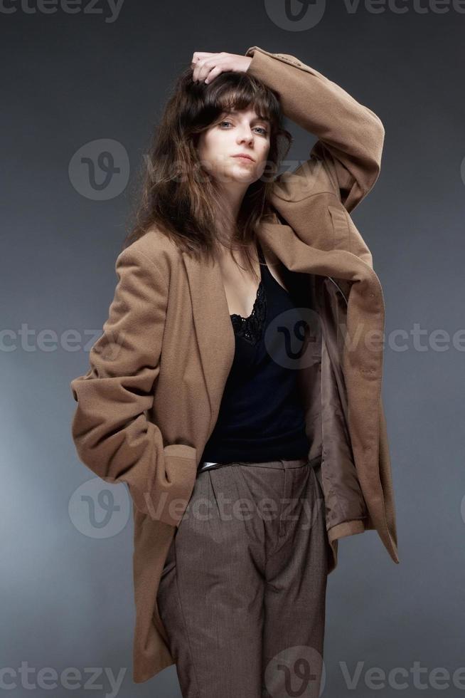 Porträt einer jungen Frau im braunen Mantel foto