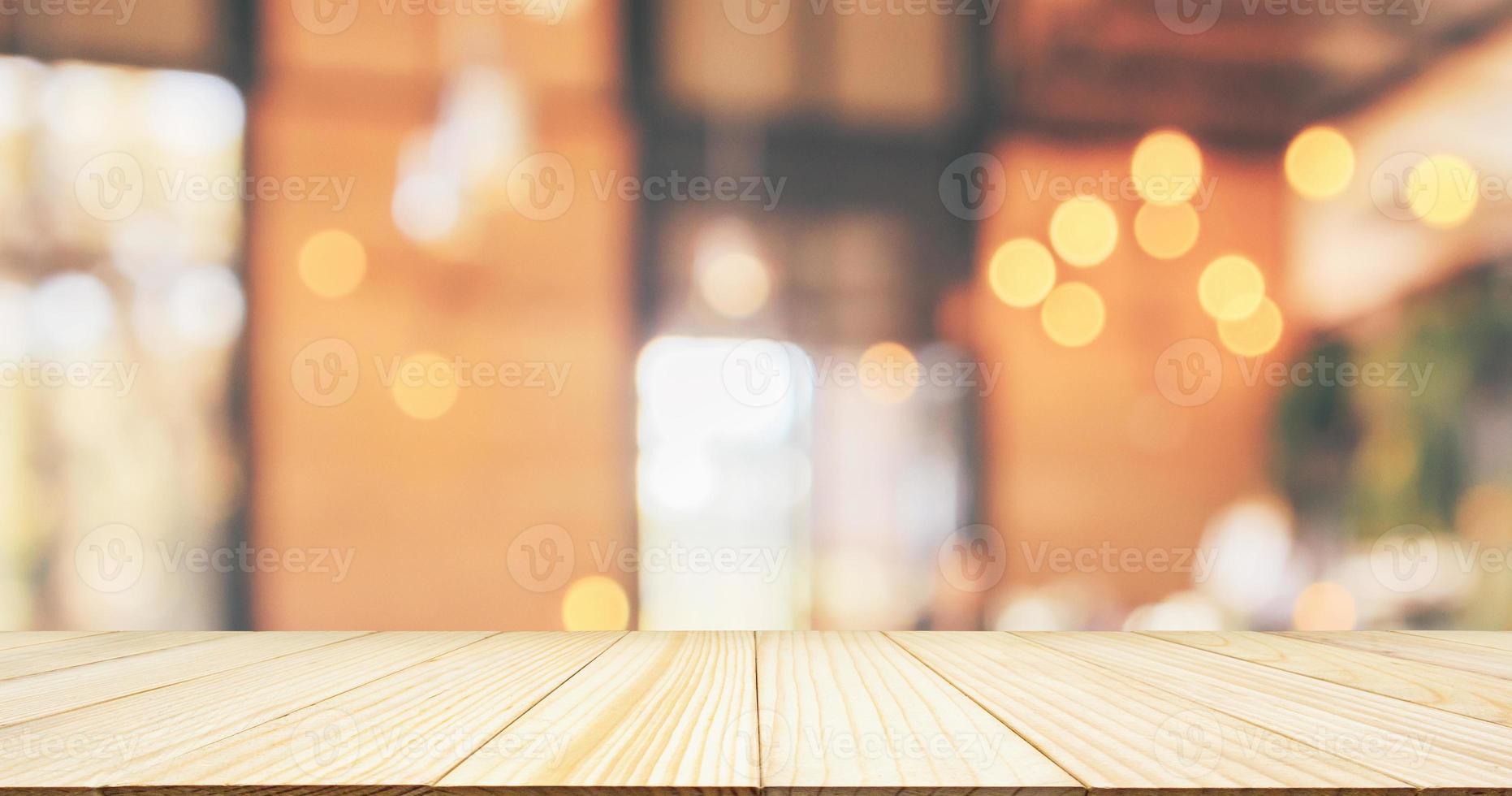 leere Holztischplatte mit Restaurant-Café oder Café-Interieur mit Kundenunschärfe abstraktem Bokeh-Licht im Vintage-Stil für Montage-Produktdisplay-Hintergrund foto