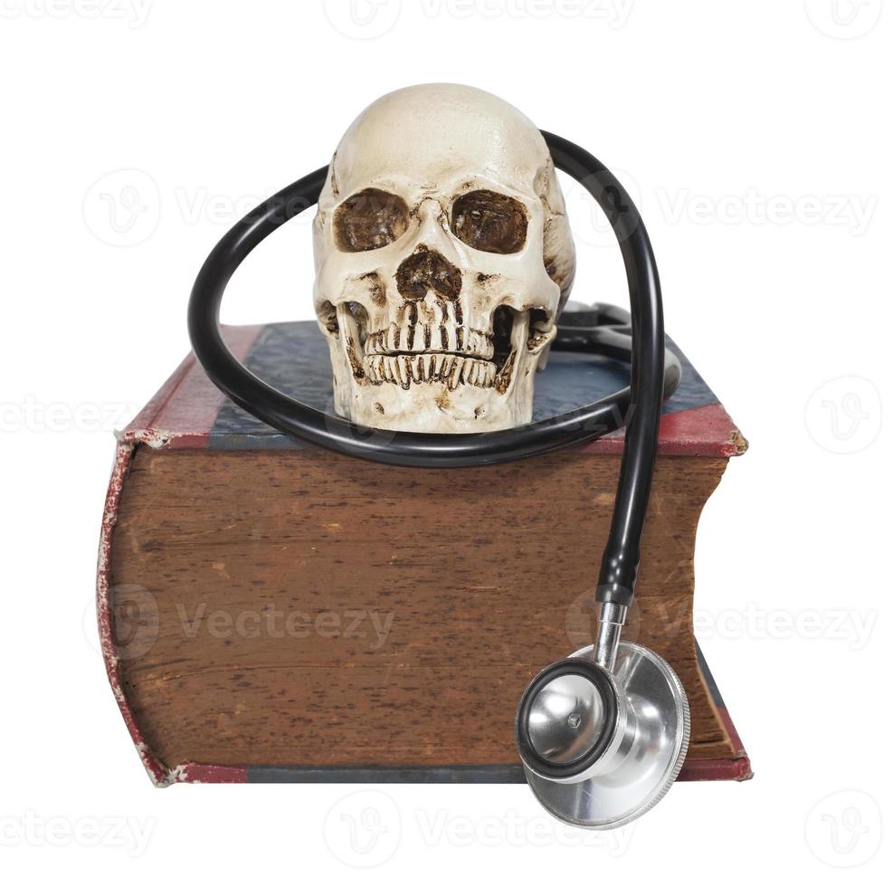 Schädel und Stethoskop auf altem Lehrbuch foto
