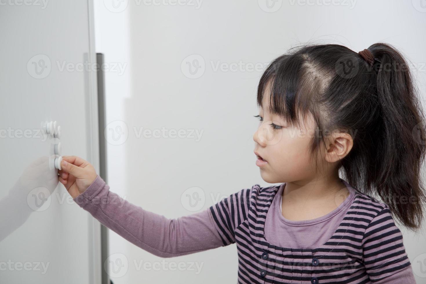 das Mädchen, das in einer weißen Tafel lernt foto