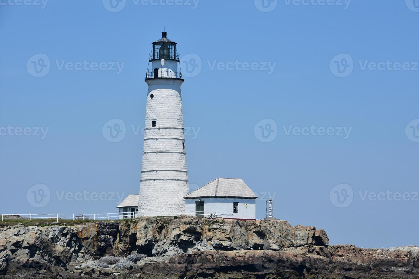 Blick auf Boston Light auf einem Felsvorsprung foto