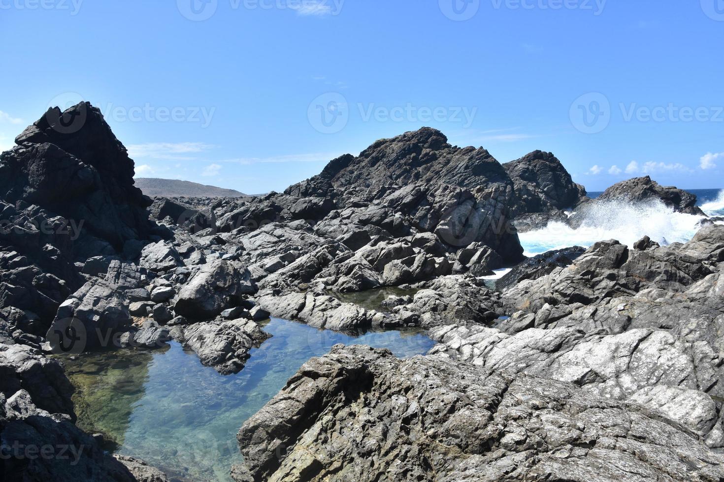 Wellen, die um einen geheimen natürlichen Pool krachen foto