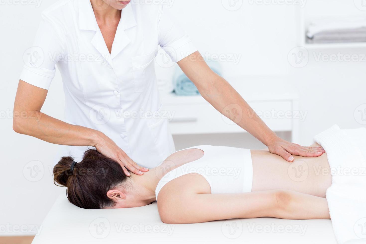 Physiotherapeut macht Rückenmassage foto