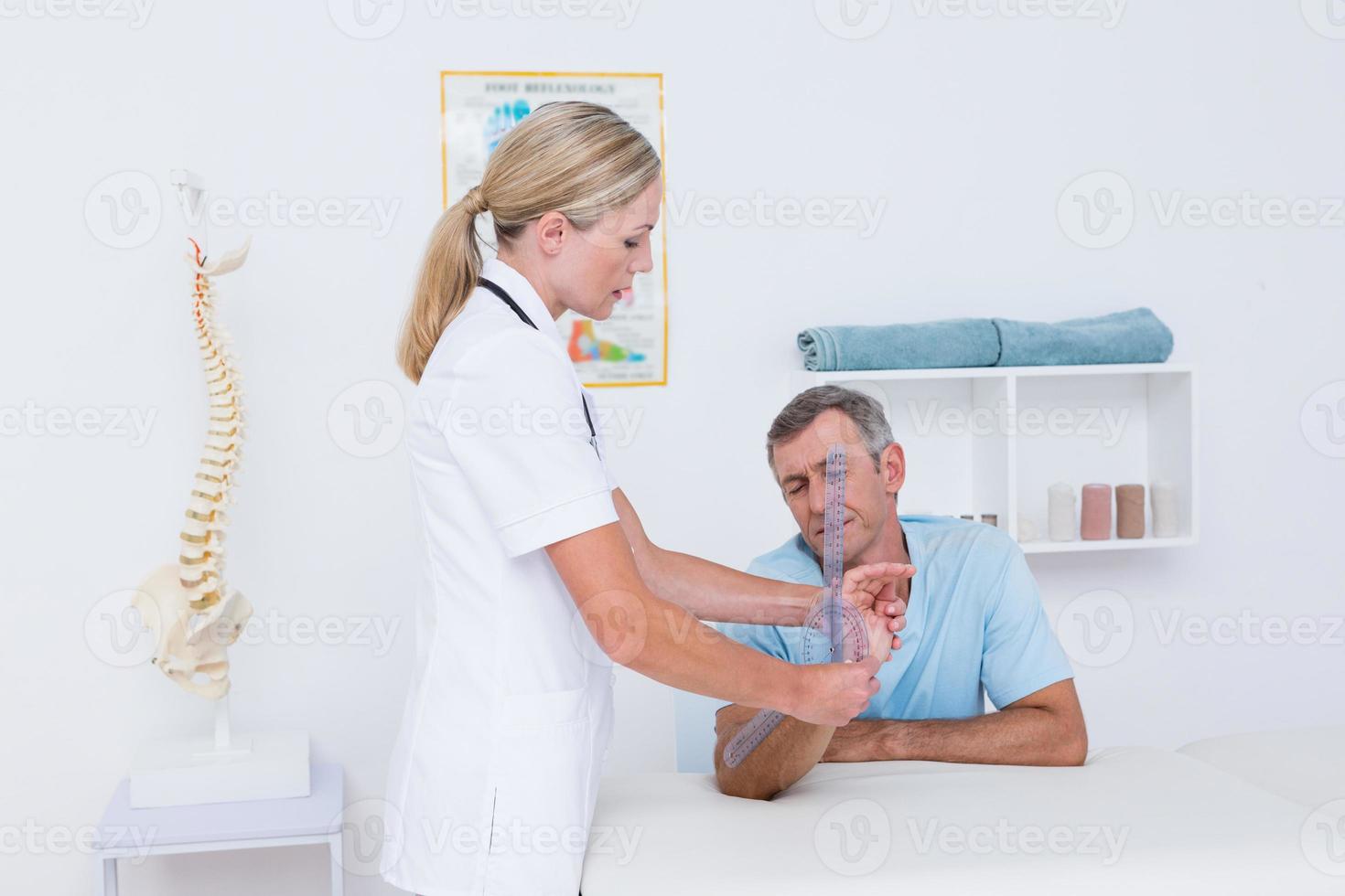 Arzt misst Handgelenk mit Goniometer foto