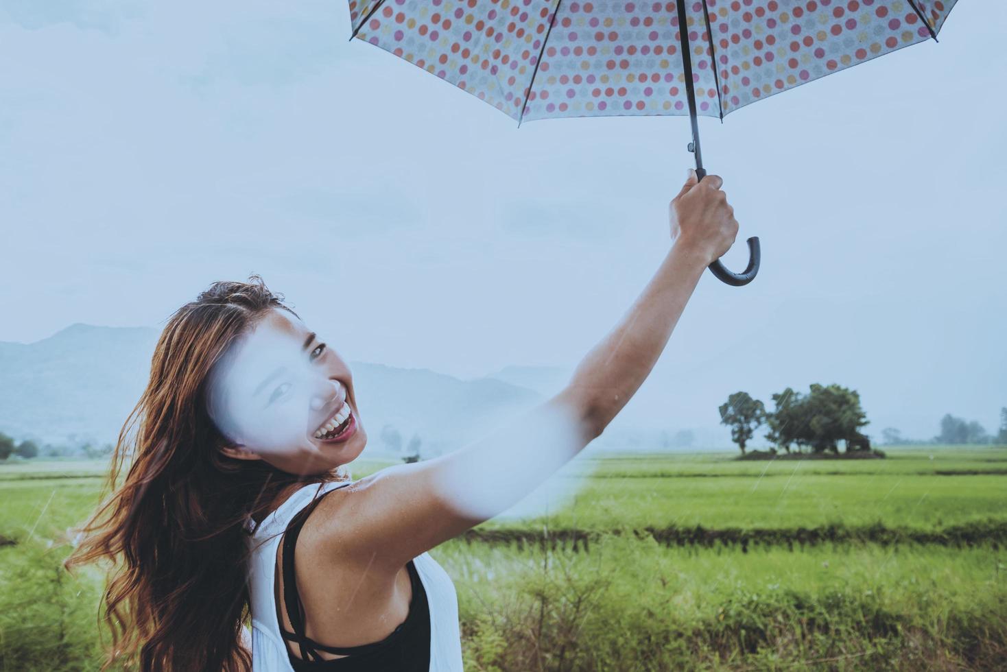 asiatische frauen reisen im urlaub entspannen. Frauen stehen in Regenschirmen. auf der wiese während der regenzeit.thailand foto