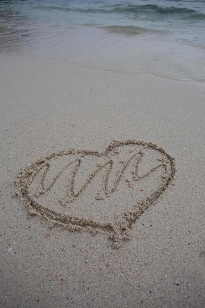 Herzen auf den Sand eines Strandes gezeichnet foto