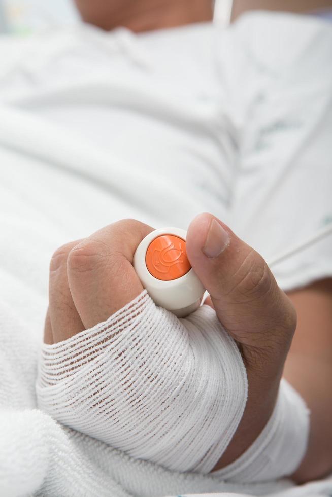 Hand, die die Notruftaste der Krankenschwester drückt foto