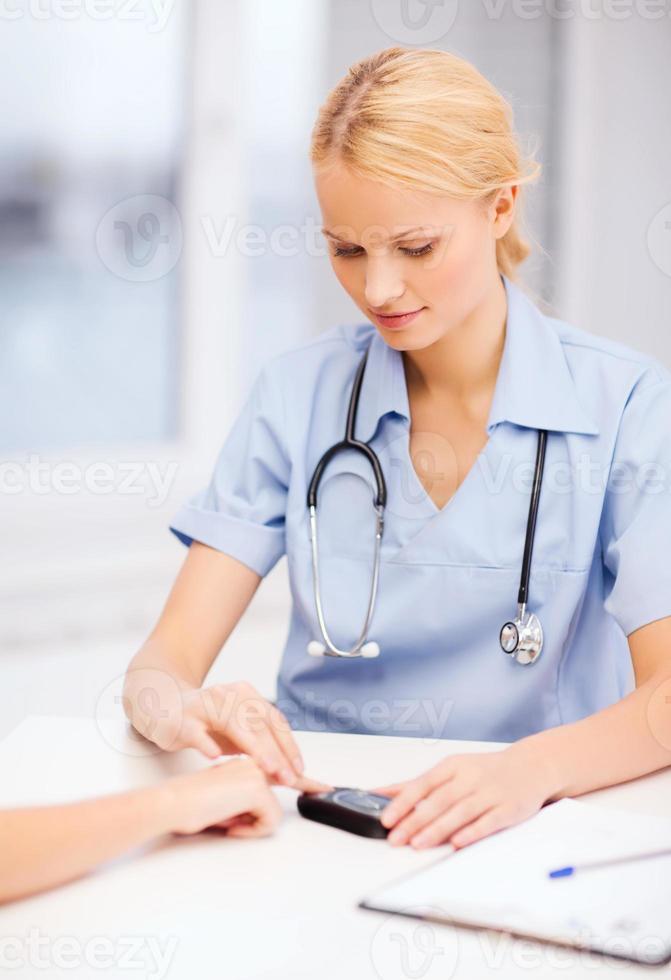 Krankenschwester oder Arzt, der einen Blutzuckertest durchführt foto
