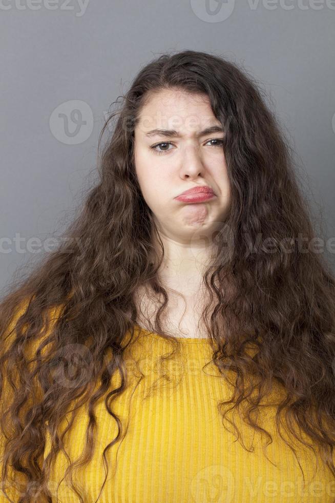 unglückliche 20s dicke Frau, die ein lustiges Gesicht macht foto