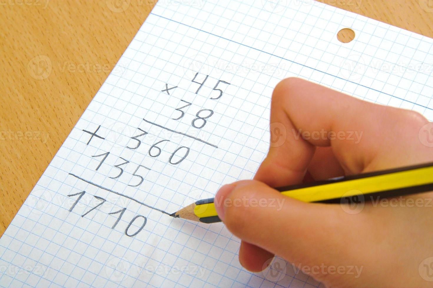 Kind macht eine Mathe-Multiplikation in der Schule foto