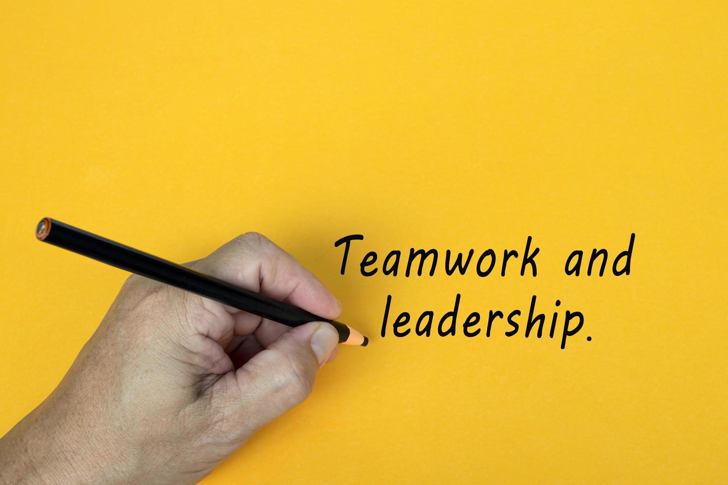 Teamwork- und Führungstext auf gelbem Hintergrund. Unternehmenskonzept. foto