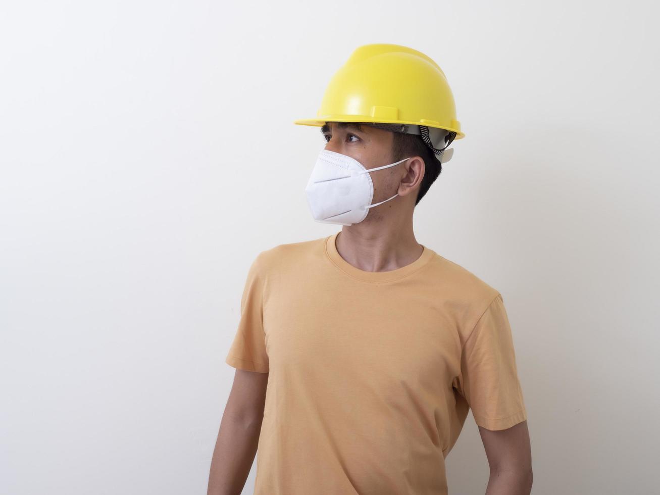 asiatische industriearbeiter tragen gelbe schutzhelme, tragen schutzmasken für ihre gesundheit foto