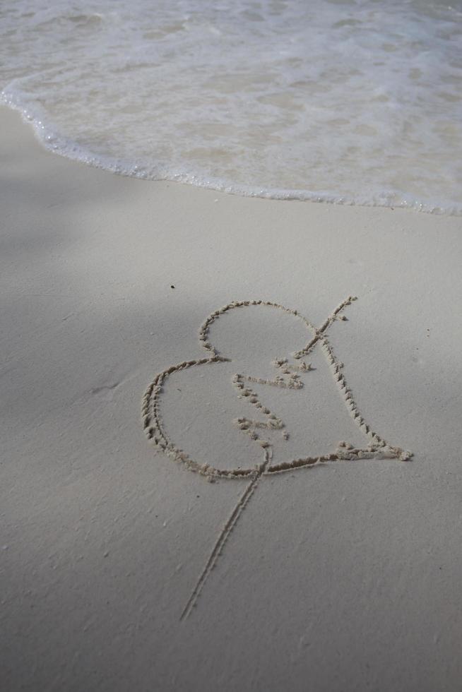 Herzen auf den Sand eines Strandes gezeichnet foto