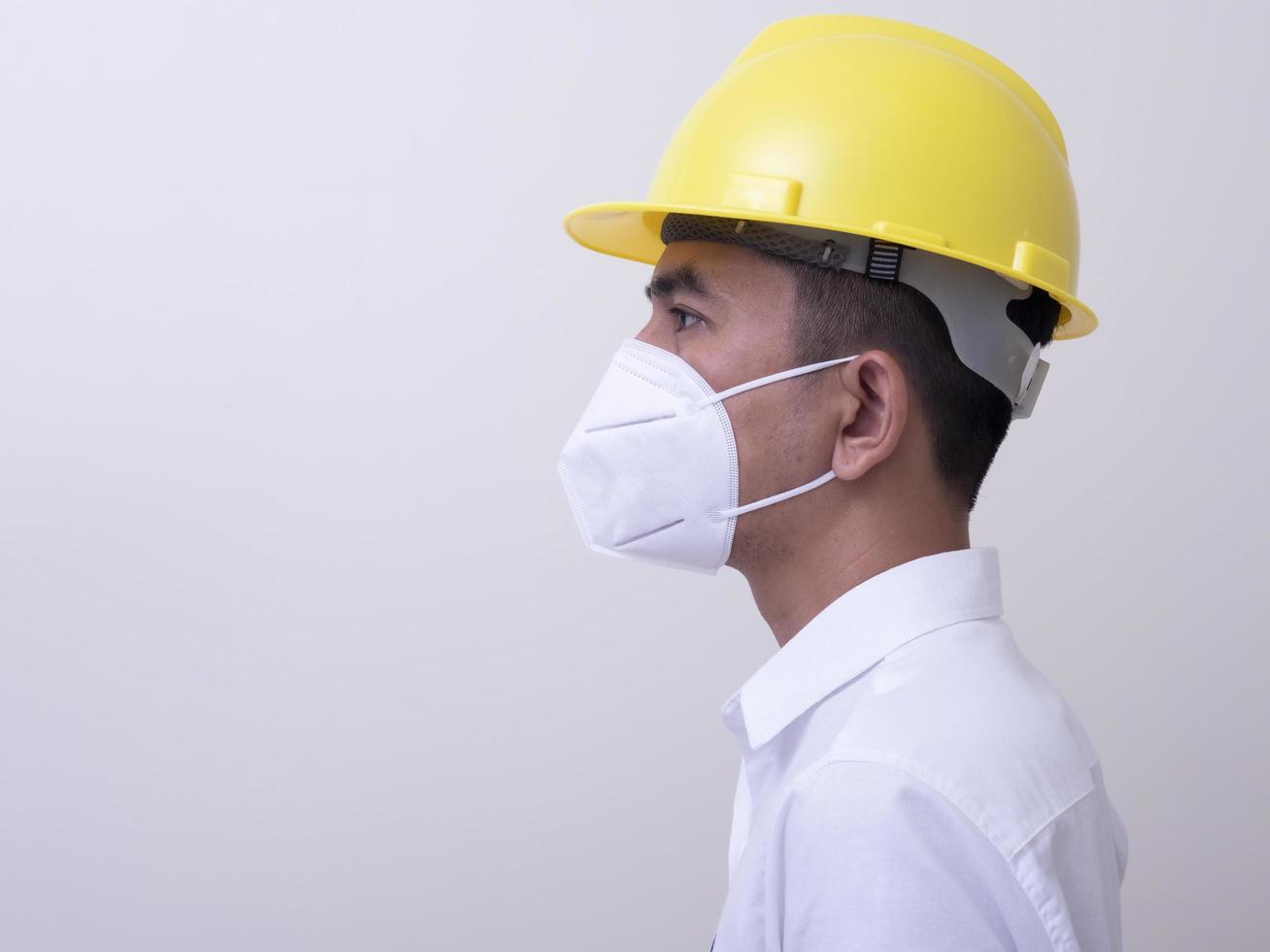 asiatische industriearbeiter tragen gelbe schutzhelme, tragen schutzmasken für ihre gesundheit foto