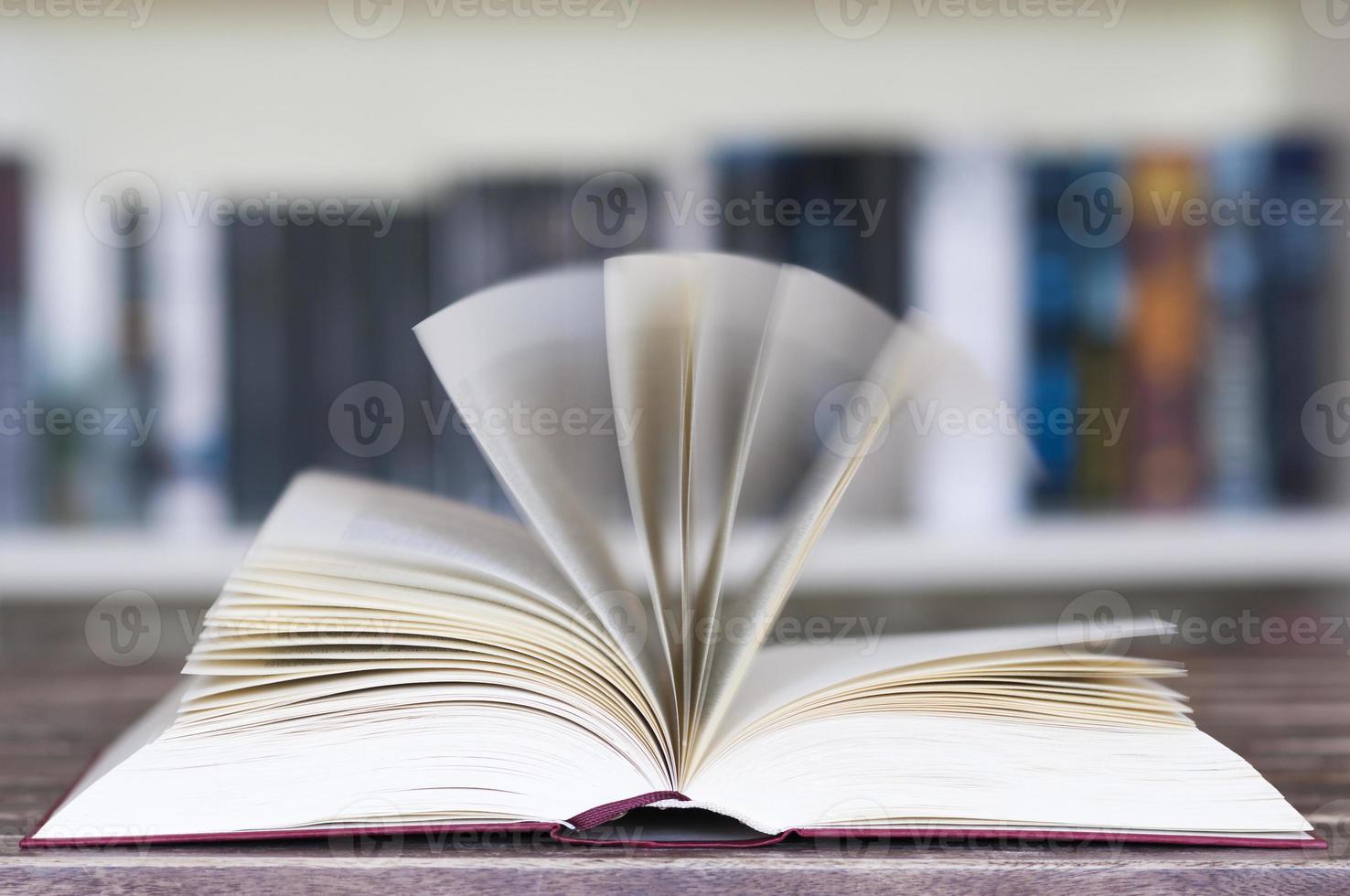 geöffnetes Buch vor dem Bücherregal foto