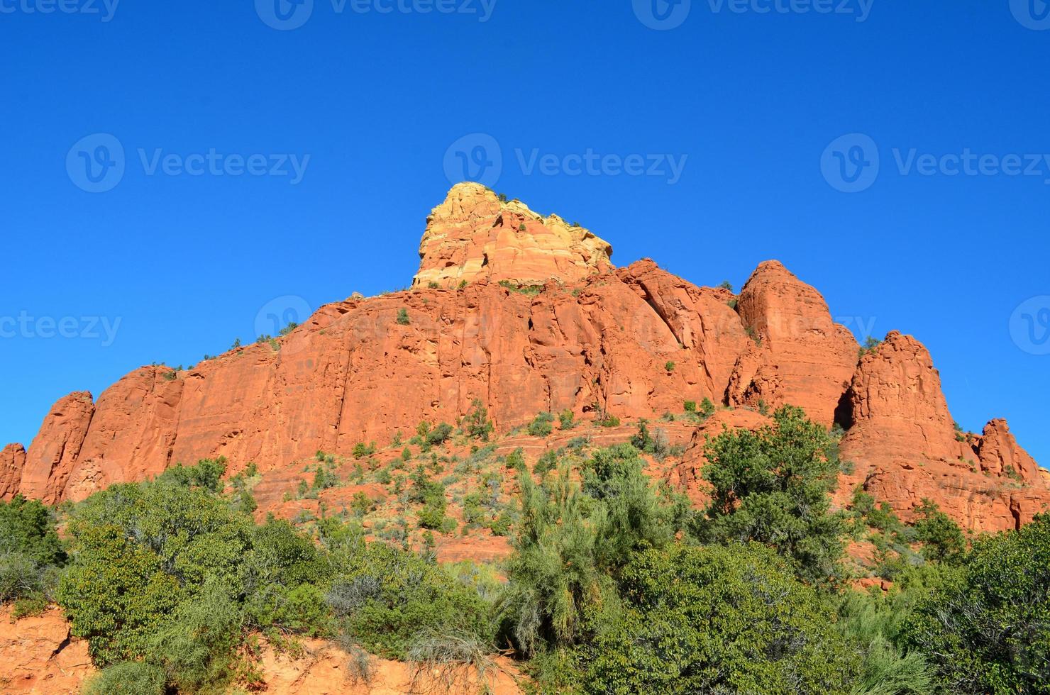 Red Rock Butte mit einem atemberaubenden roten Felsen, der darauf scheint foto