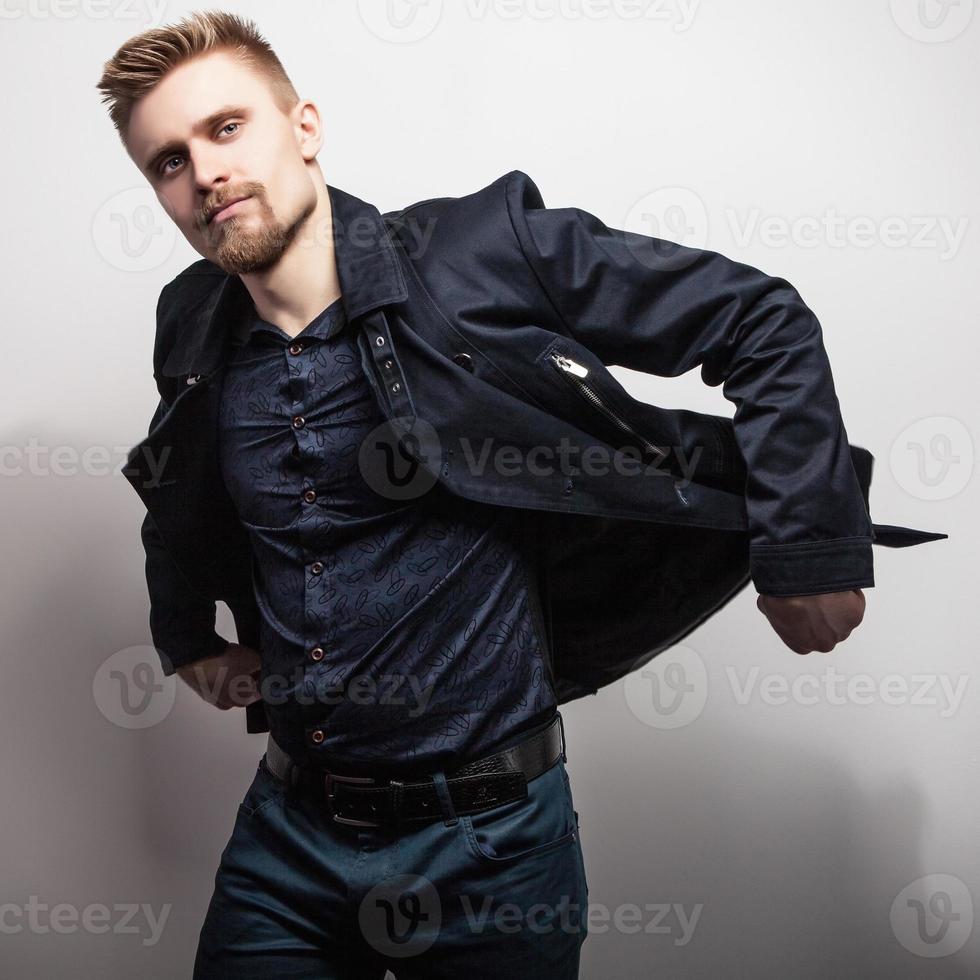 eleganter junger hübscher Mann im schwarzen Mantel. Studio Mode Porträt. foto