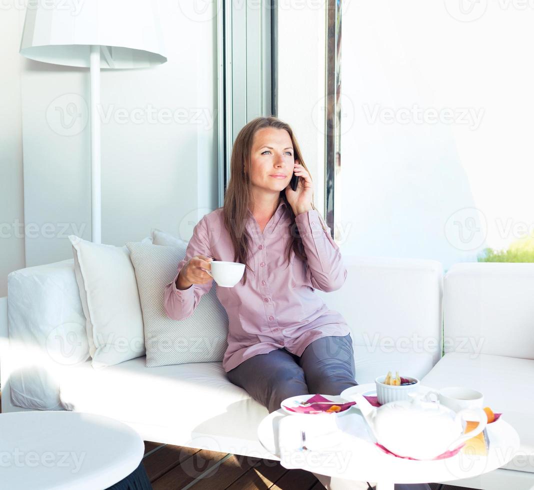Geschäftsfrau spricht auf dem Handy in einem Kaffeehaus foto