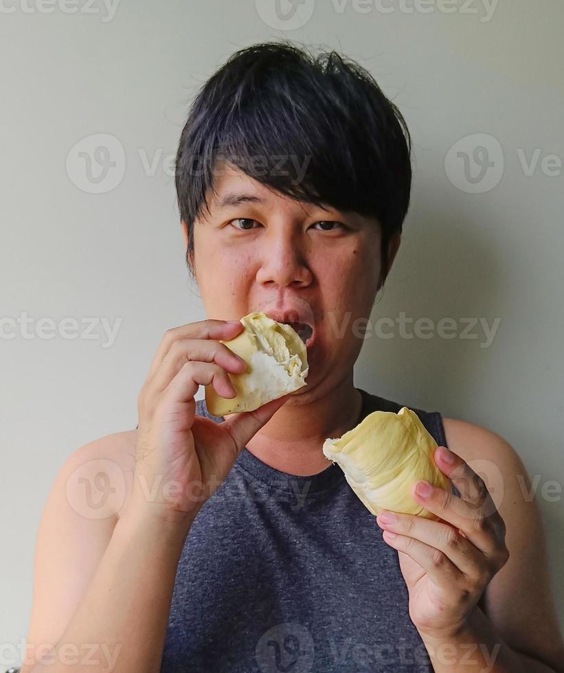 Junge asiatische Männer essen Durian. Früchte mit Geruch sind in Thailand beliebt. foto