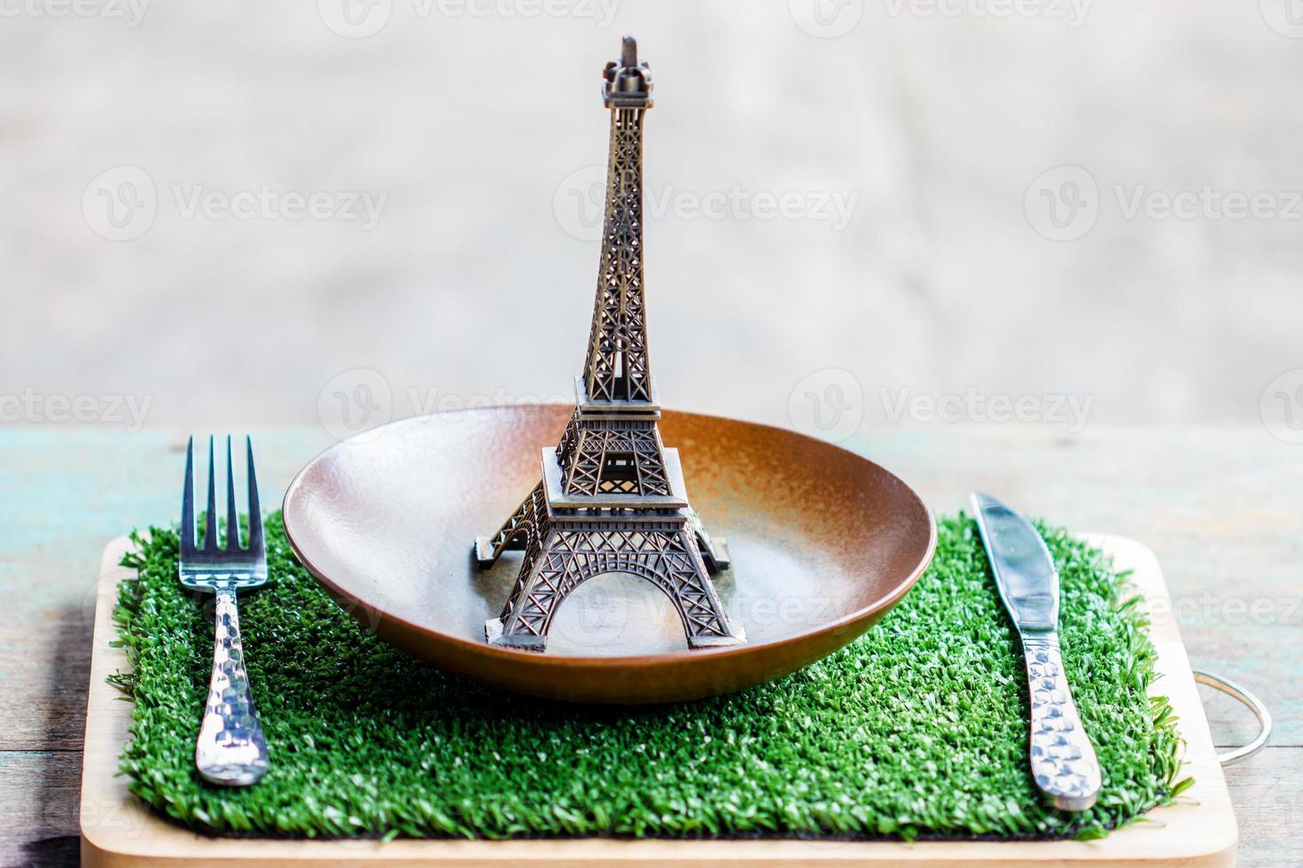 Eiffelmodell auf Tischdekoration von Platte, Gabel, Messer. foto