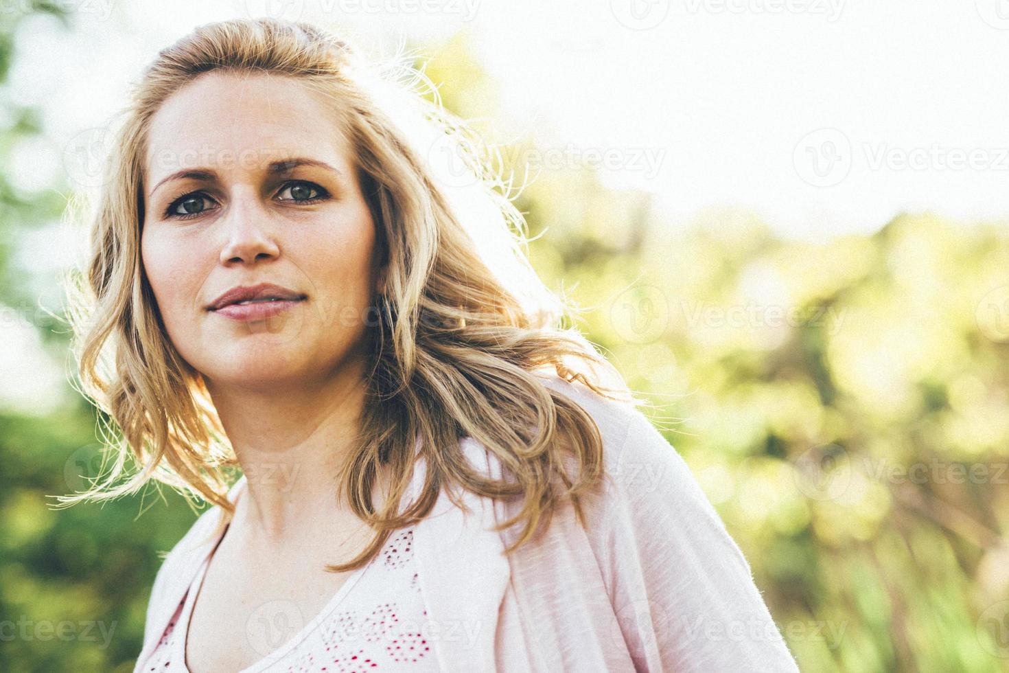 schöne junge Frau, die im Sommer draußen lächelt foto