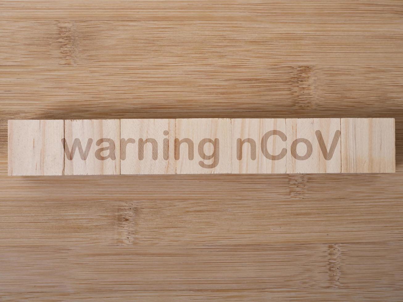 Warnung ncov-Wort auf Holzblock geschrieben. warnender ncov-text auf holztisch für ihr design, draufsicht des coronavirus-konzepts foto