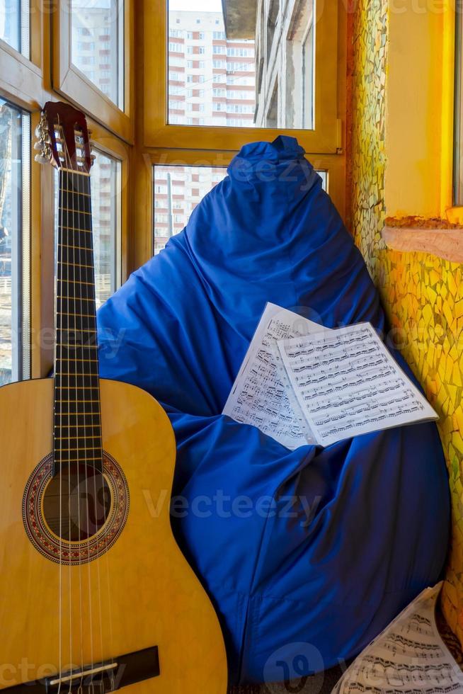 Komposition mit Gitarre und Noten auf Balkon foto