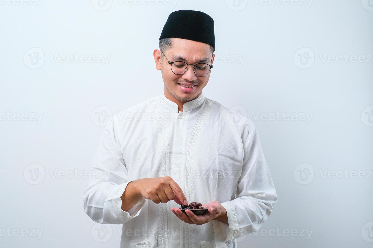 asiatischer muslimischer Mann, der Dattelfrüchte isst foto