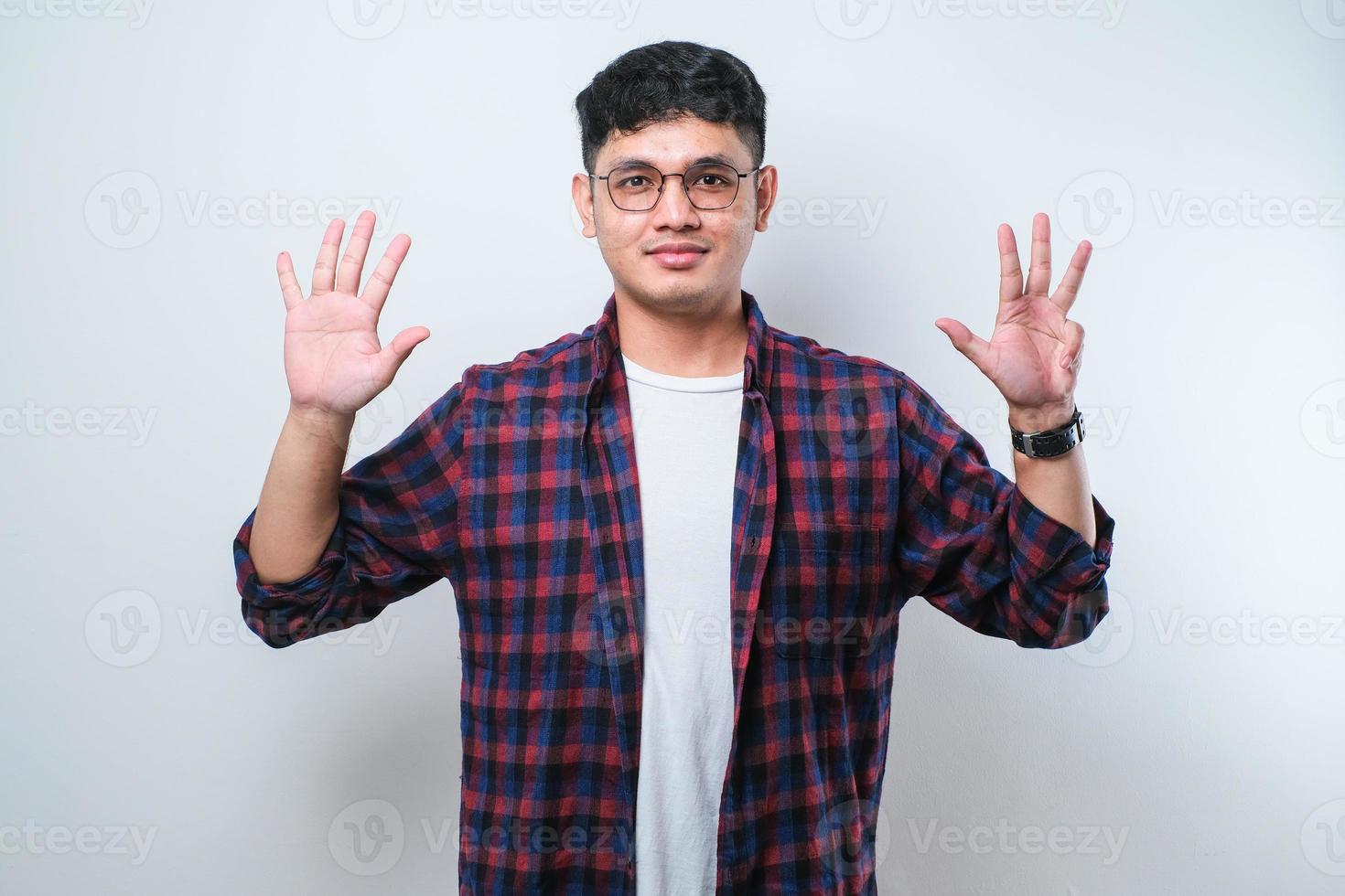 junger gutaussehender asiatischer mann, der lässige kleidung trägt und mit den fingern nummer neun zeigt und nach oben zeigt, während er selbstbewusst und glücklich lächelt foto