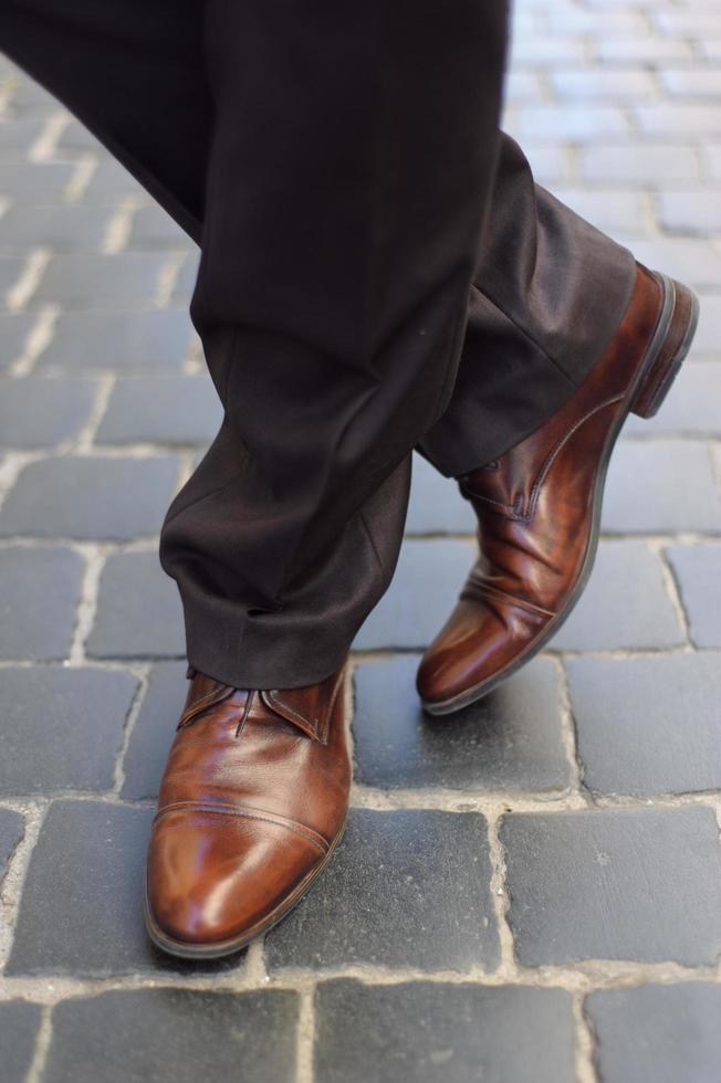 Männerfüße in Schuhen auf dem Bürgersteig foto